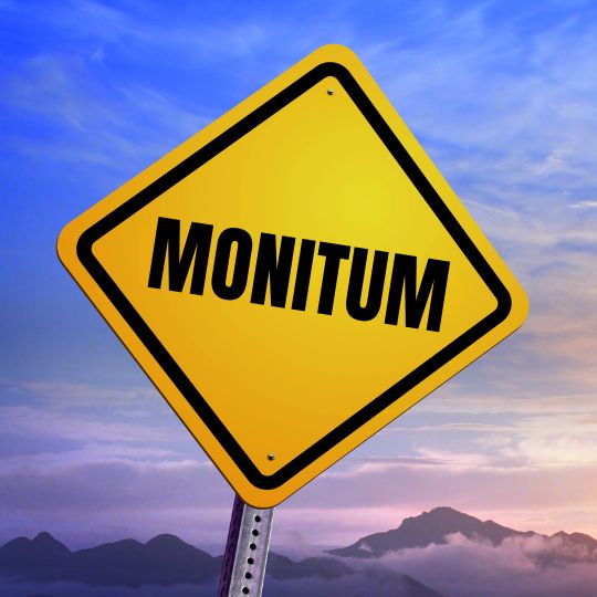 Road sign with
                      the word Monitum on it photographed against a
                      sunrise sky