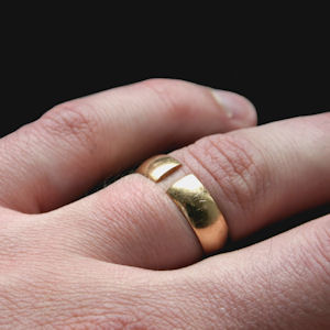 Gold wedding ring with a split in it
pictured on a person's ring finger