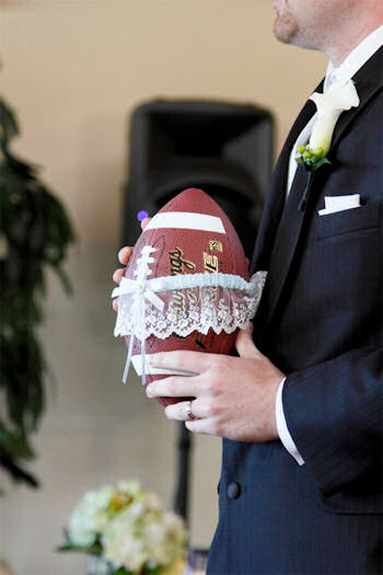 Groom holding football
with garter on it