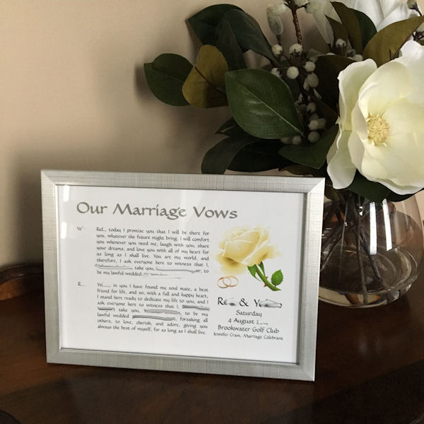 Wedding Vows in Silver Frame next to vase of
white magnolia flowers