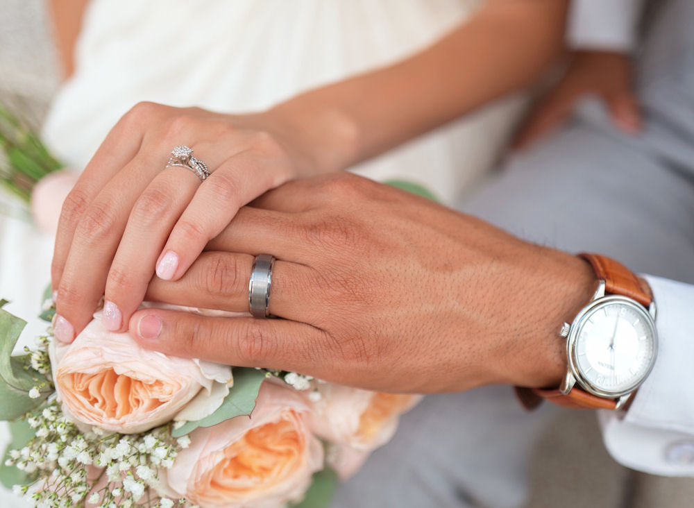 Marrying couple hands wearing rings with
watch