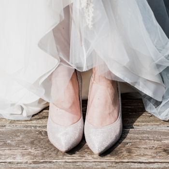 Bridal shoes
beneath wedding gown hem